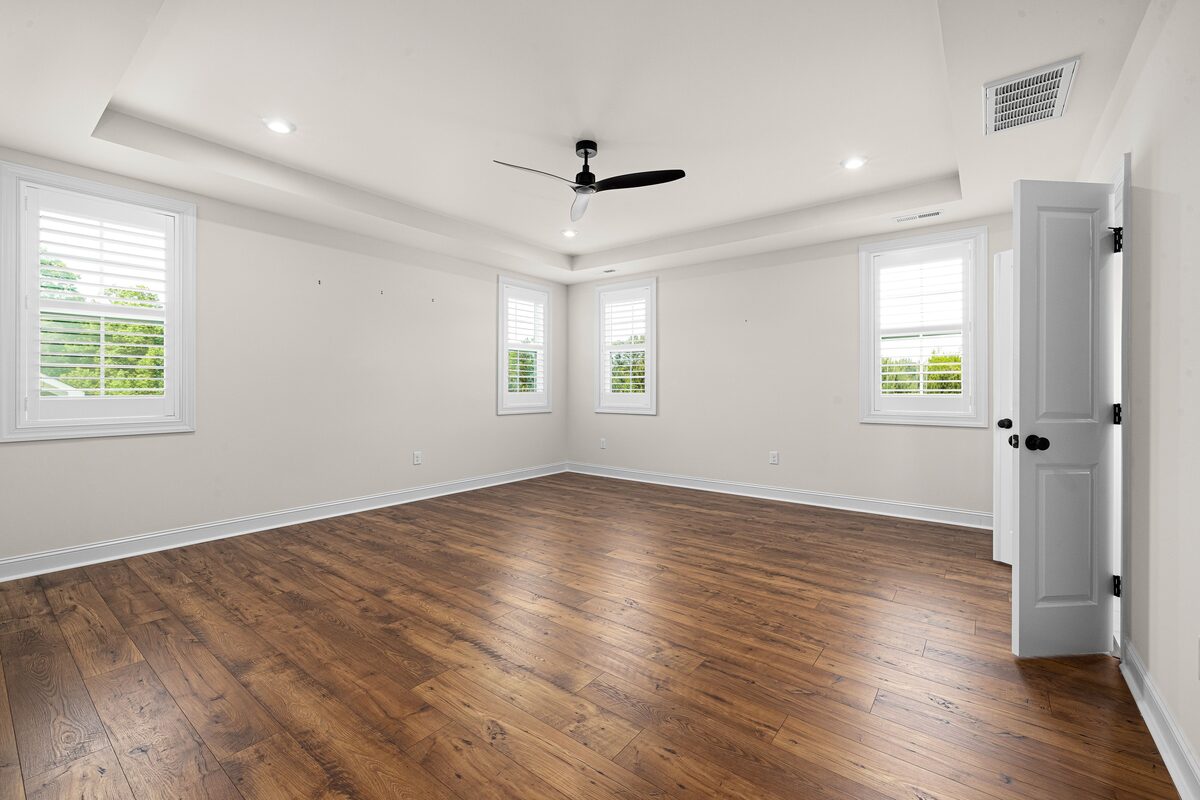 Pièce vide aux murs blancs et au parquet clair, prête pour l'état des lieux.